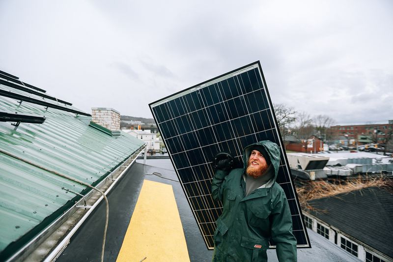 Solar installers working on a rooftop photovoltaic array